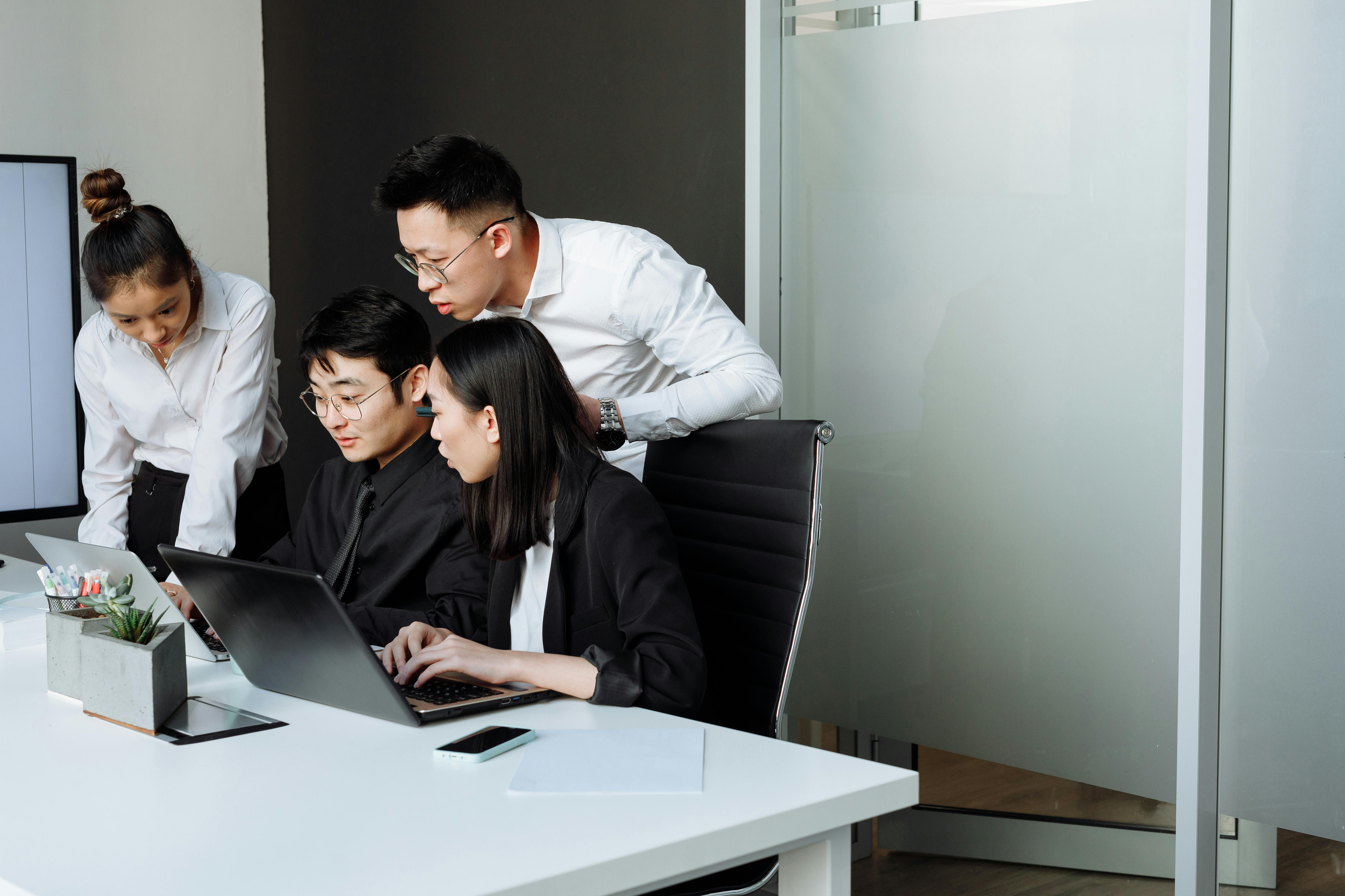 Business team reviewing project delivery information on a laptop